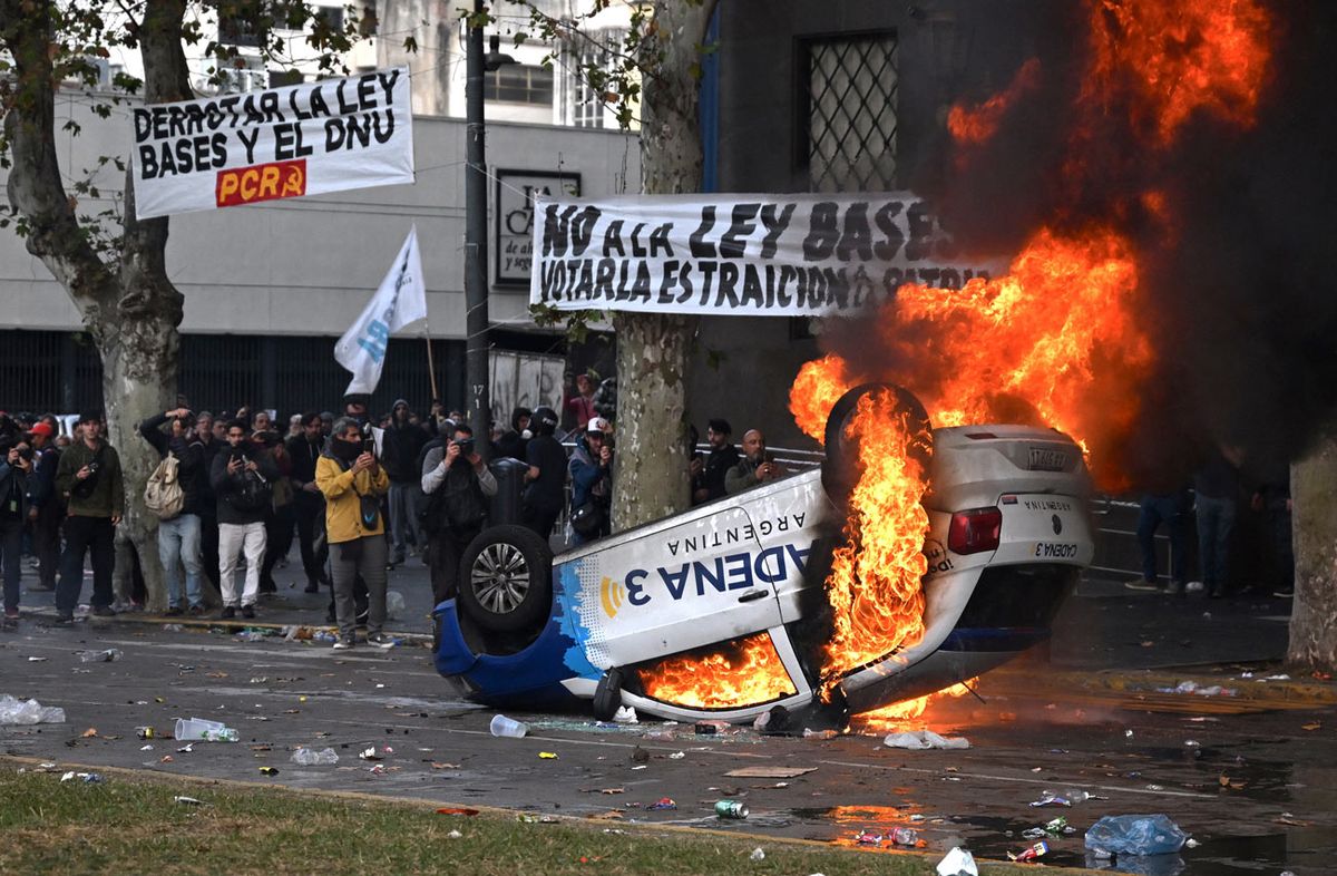 Foto: Tomás Cuesta / AFP. Manifestantes incendian el auto de un medio de comunicación, en Buenos Aires, el 12 de junio de 2024. Foto: Tomás Cuesta / AFP. Manifestantes incendian el auto de un medio de comunicación, en Buenos Aires, el 12 de junio de 2024.