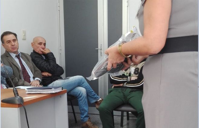 FOTO: La fiscal muestra el calzado que llevaba Valentina cuando fue atacada. Al fondo, de pantalón verde, uno de los acusados.