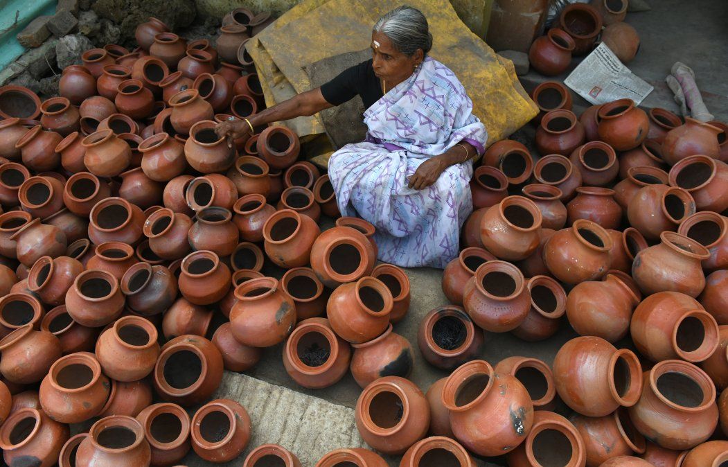 Una mujer india acomoda vasijas de barro para el festival Hindú Pongal.