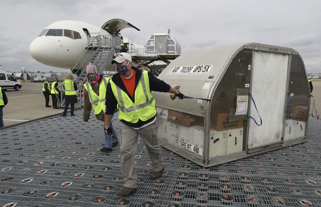 Empleados de la empresa de correos privada UPS transportan contenedores de la vacuna contra Covid-19 en el aeropuerto de Louisville, Kentucky. La vacunación masiva en EEUU. comienza en cuestión de horas