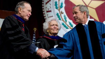 Presidente George W. Bush (derecha) le da la mano a su padre, el expresidente George H.W. Bush (izquierda) frente a su madre, Barbara Bush, luego de participar en una ceremonia de graduación en la Texas A&M University en la Reed Arena en College Station, Texas.