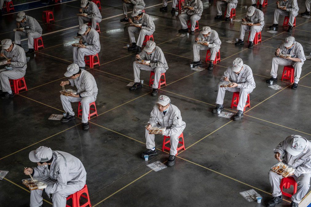 Empleados almuerzan en la planta de Honda en Whuhan, China, ciudad donde surgió el coronavirus