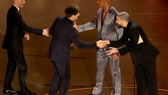 Momento en el que entregan la estatuilla a los realizadores de Zona de interés. Foto: AFP