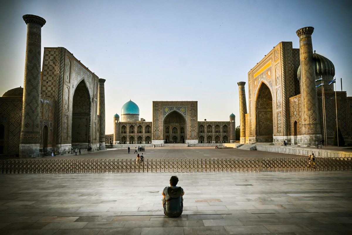 Un hombre está sentado en la plaza Registan en el centro de Samarcanda el 13 de septiembre de 2022. Foto: AFP