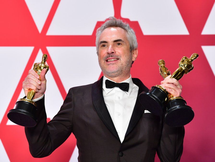 Alfonso Cuaron posa para la prensa con sus premios por Mejor Director, Mejor Película Extranjera y Mejor Fotografía