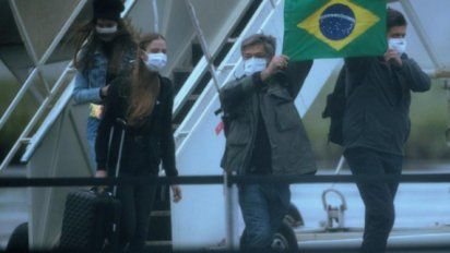 Pasajeros salen de uno de los aviones en los que fueron repatriados de la ciudad china de Wuhan 34 brasileños y sus parientes, tras aterrizar en una base de Anápolis (Brasil)