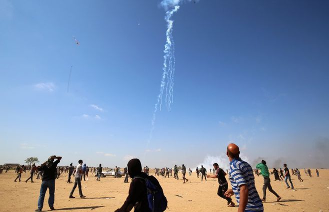 Los manifestantes palestinos observan caer gas lacrimógeno arrojado desde un avión no tripulado israelí el 15 de mayo último.