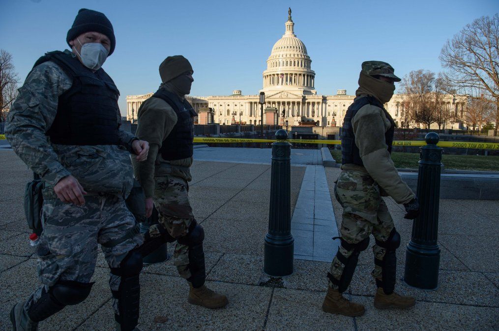 Los miembros de la Guardia Nacional de DC pasan frente al Capitolio, el 7 de enero de 2021, un día después de que los partidarios del presidente saliente Trump irrumpieran en el edificio.