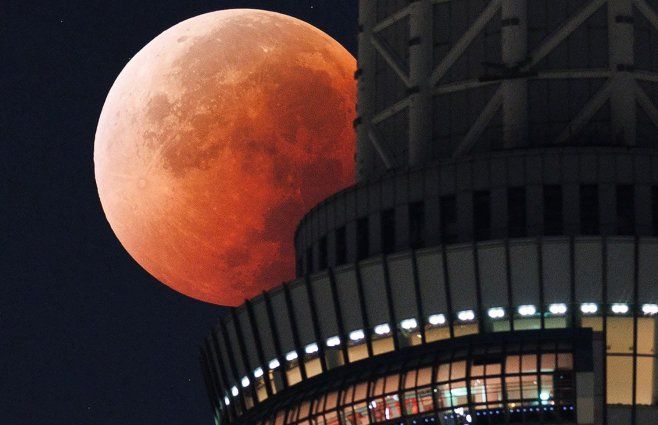 Foto: AFP. La Luna aparece detrás del Tokyo Skytree, Japón, durante el eclipse lunar total.