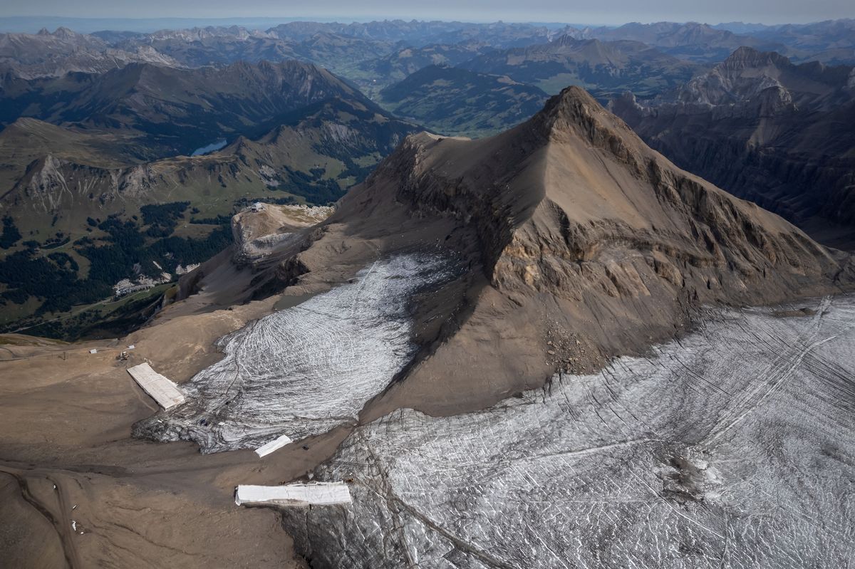 Esta fotografía aérea fue tomada el 13 de septiembre de 2022 en el complejo Glacier 3000 sobre Les Diablerets muestra el paso de Tsanfleuron libre del hielo que lo cubrió durante al menos 2000 años junto a mantas que cubren la nieve de la última temporada de invierno para evitar que se derrita. Foto: AFP