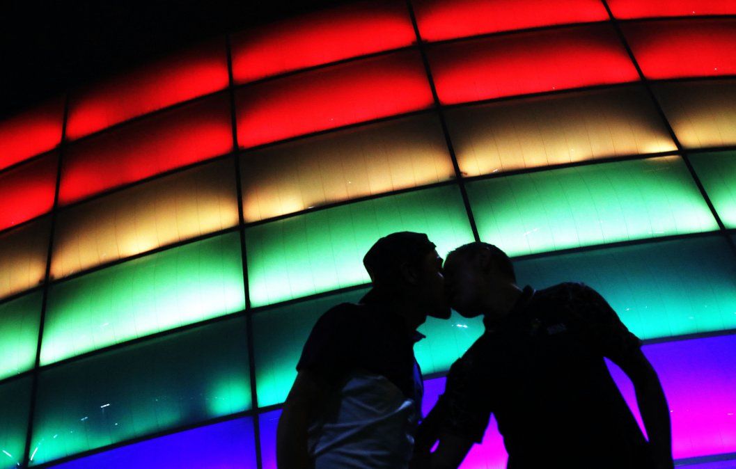 Camilo Barato y Cristian Toquica besan el Movistar Arena coloreado con la bandera del arco iris durante el Día Internacional del Orgullo LGBTIQ en Bogotá