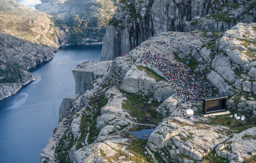Personas en la montaña cerca de Preikestolen en el oeste de Noruega se preparan para ver la película Misión Imposible en el mismo lugar donde fue filmada.