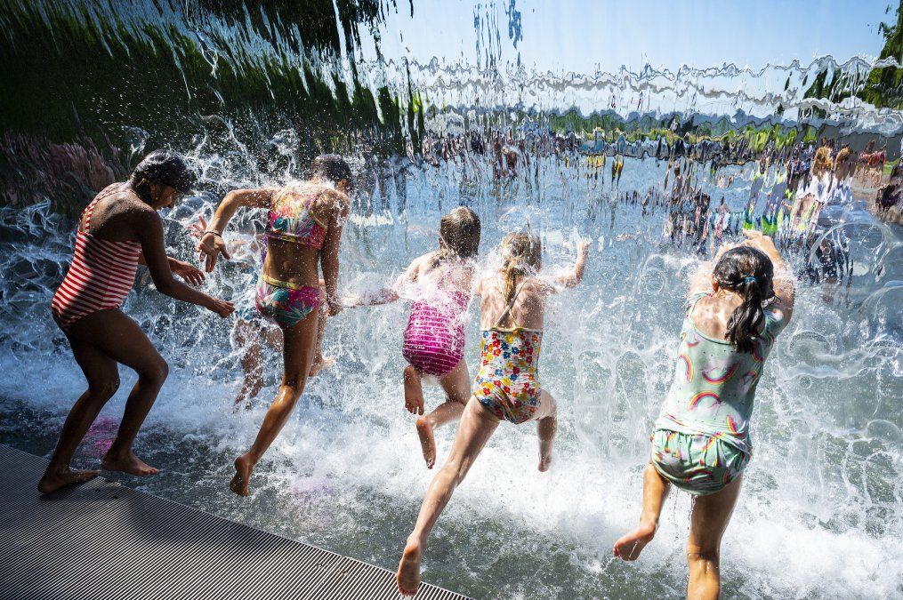 Las niñas chapotean en una cascada en un parque en Washington, DC, el 28 de junio de 2021, mientras una ola de calor recorre gran parte de los Estados Unidos.