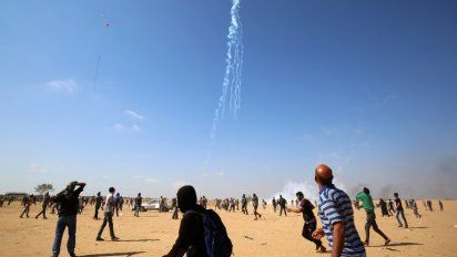 Los manifestantes palestinos observan caer gas lacrimógeno arrojado desde un avión no tripulado israelí el 15 de mayo último.