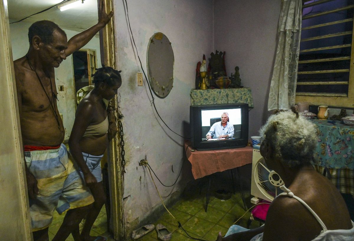 La gente ve al presidente cubano Miguel Díaz-Canel hablar sobre la situación de la electricidad en el país durante una aparición especial en televisión, en La Habana.