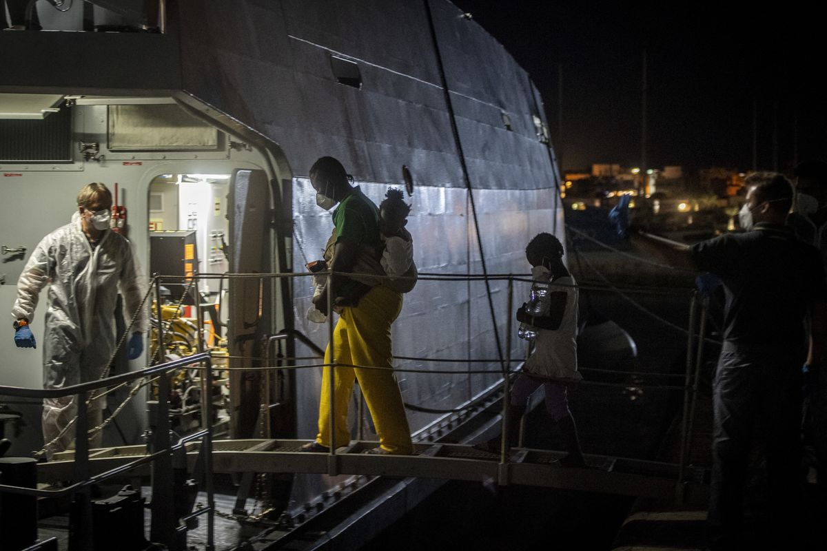 Migrantes abordan un buque militar de la Guardia di Finanza y la Armada antes de ser trasladados desde la llamada instalación de procesamiento operativo Hotspot de migrantes en la isla de Lampedusa, en el sur de Italia, al sur de Sicilia, a otro centro, el 10 de julio de 2022.