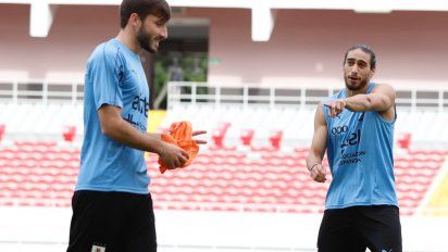 Matías Viña con El pelado Cáceres. El experiente recibe al nuevo. Una de las apuestas de Tabárez para el recambio generacional en la celeste.&nbsp;