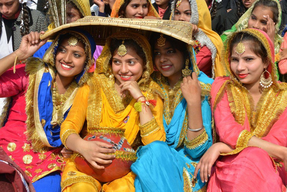 Escolares indias vestidas con trajes tradicionales Giddha posan para una foto antes de bailar danzas tradicionales.