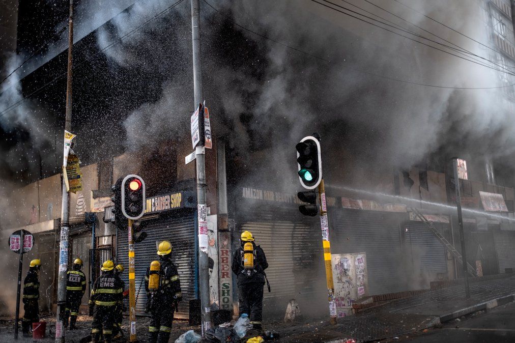 Bomberos tratan de extinguir el fuego en un edificio presuntamente secuestrado en el centro de Johannesburgo.