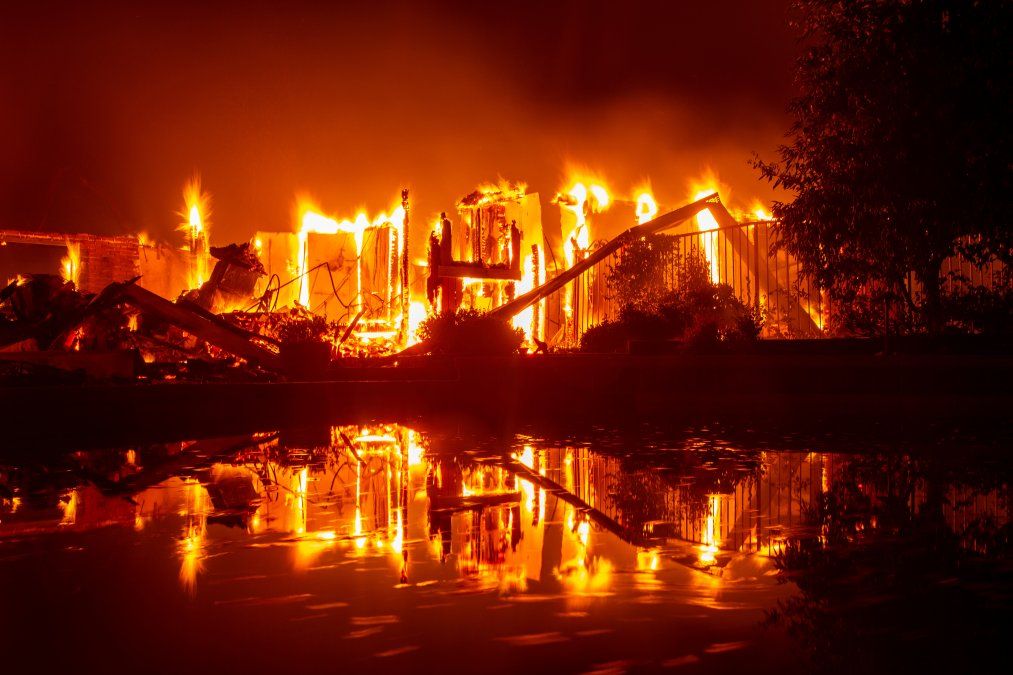Una casa en llamas se refleja en una piscina en California