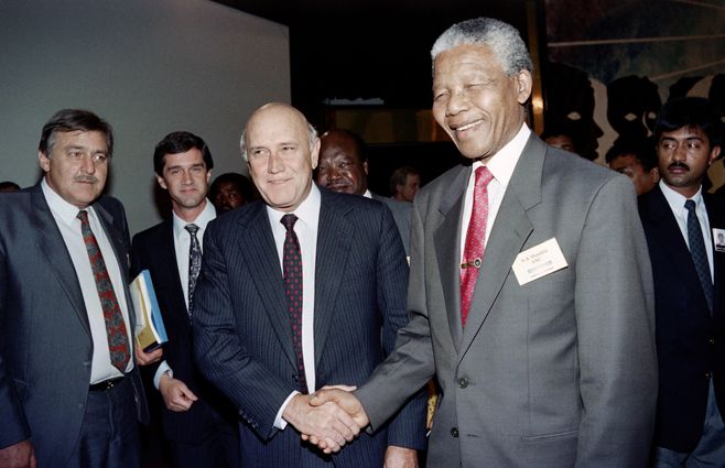 El 16 de mayo de 1992, el vicepresidente del ANC, Nelson Mandela (derecha), saluda al presidente de Sudáfrica, FW De Klerk (centro). Observa la escena el ministro de Relaciones Exteriores, Pik Botha.&nbsp; Están en la Convención por una Sudáfrica democrática. (CODESA) en Johannesburgo.