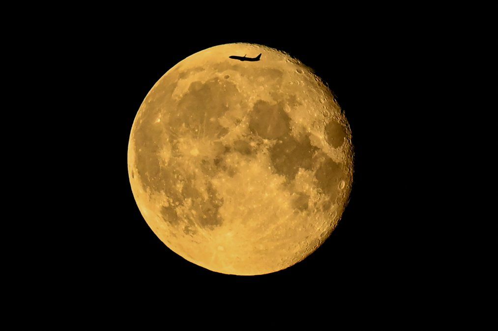 La silueta de unavión delante de la luna menguante en Moscú a última hora del 25de julio.