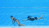La entrenadora de EE. UU., Andrea Fuentes (D), nada para salvar a Anita Alvarez (L), de EE. UU., del fondo de la piscina durante un incidente en la final femenina de natación artística libre en solitario, durante el Campeonato Mundial Acuático de Budapest 2022. Foto: AFP.