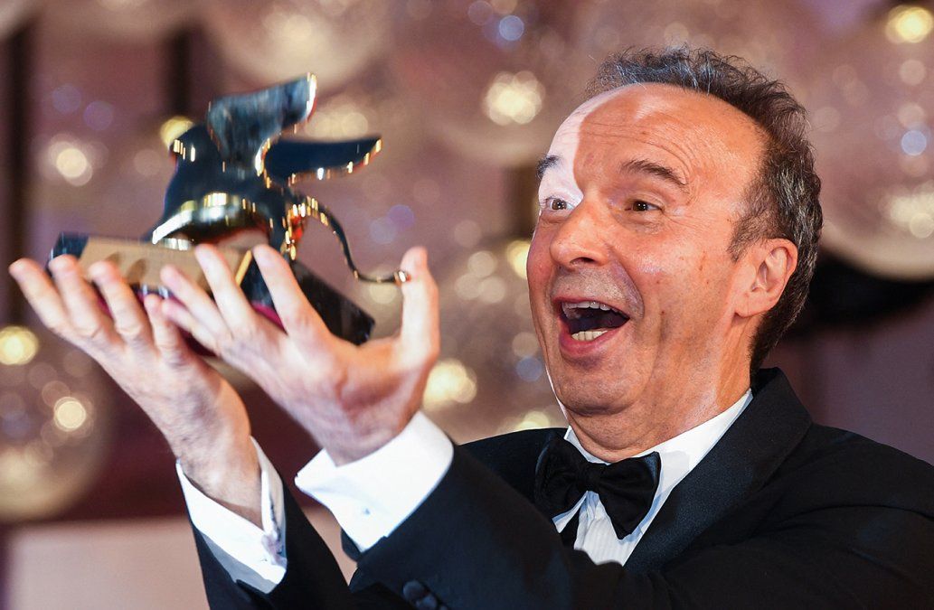 Elactor y director italiano Roberto Benigni lanza su premio León deOro al aire mientras posa para los fotógrafos después de recibir unLeón de Oro por su trayectoria, tras la ceremonia de apertura del 78° Festival de Cine de Venecia.