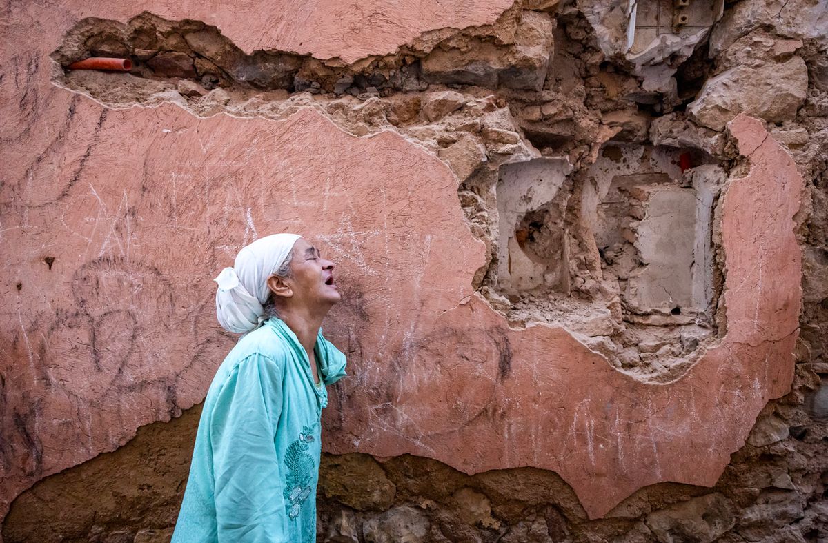 Una mujer reacciona de pie frente a su casa dañada por un terremoto en la ciudad antigua de Marrakech el 9 de septiembre de 2023. Un poderoso terremoto que sacudió Marruecos a finales del 8 de septiembre cobró la vida de más de 600 personas, según cifras del Ministerio del Interior, lo que llevó a residentes aterrorizados a huir de sus hogares en mitad de la noche.