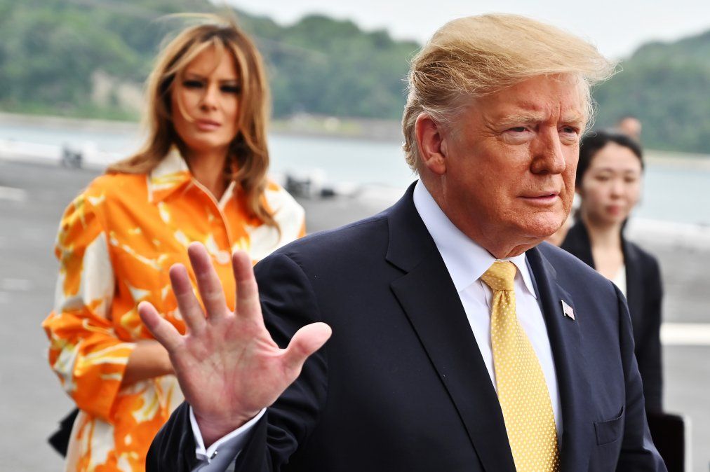 El presidente de Estados Unidos, Donald Trump saluda mientras su esposa Melania mira hacia la defensa marítima japonesa.