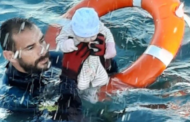 El policía de nombre Juan Francisco rescata un bebé de las aguas en Ceuta. La foto pertenece a la Guardia Civil española
