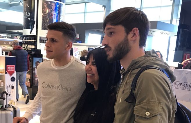 Matías Viña y Giovanni González posan con una hincha en el Aeropuerto de Carrasco.&nbsp;