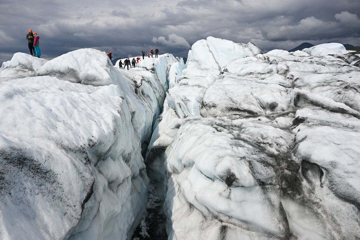Los visitantes caminan sobre el hielo a lo largo de una grieta durante una visita guiada a Matanuska, un glaciar de 43,5 km de largo que alimenta agua al río Matanuska, el 10 de julio de 2022, cerca de Palmer, Alaska.&nbsp; Si bien Alaska alberga alrededor de 25 000 glaciares, los estudios sugieren que el aumento de las temperaturas globales relacionado con el cambio climático está provocando el derretimiento de estos en todo el mundo.&nbsp; Foto: AFP.