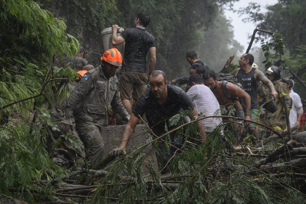 Bomberos, trabajadores municipales, la policía y voluntarios trabajan en el rescate de personas tras los daños causados por la fuerte lluvia en Rio de Janeiro.&nbsp;