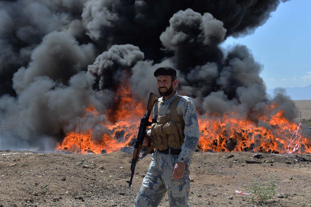 Un hombre afgano de seguridad hace guardia cuando queman drogas y bebidas incautadas