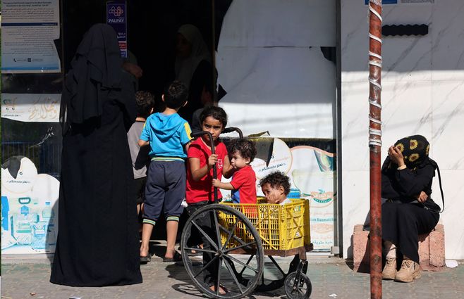 Familia palestina al sur de la Franja de Gaza, en el límite con Egipto, reciben alimentos ingresados por los camiones de ayuda humanitaria que ingresaron este sábado. Foto: AFP.