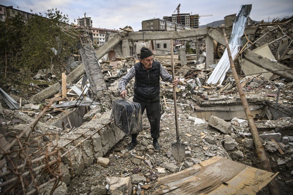 Un oficial de policía retirado busca pertenencias en los restos de su casa bombardeada en Stepanakert.