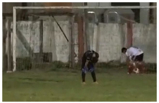 El golero mirando al suelo, manos en la rodilla, totalmente desconsolado. Atrás un delantero rival la va a buscar adentro del arco. 