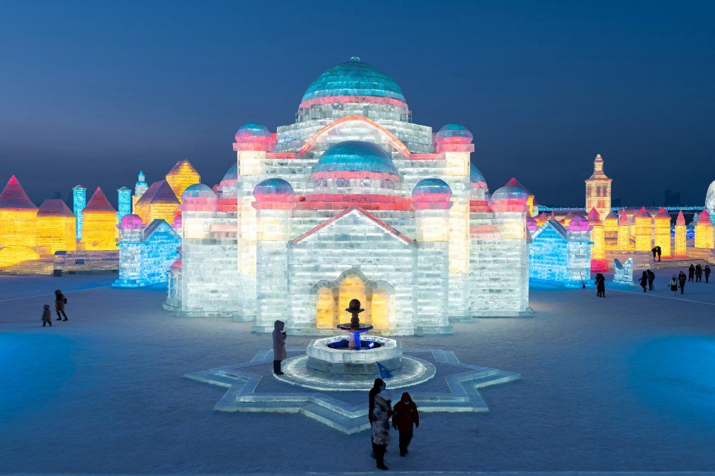 La gente mira esculturas de hielo en el Festival de hielo y nieve de Harbin en Harbin, en la provincia de Heilongjiang, en el noreste de China.