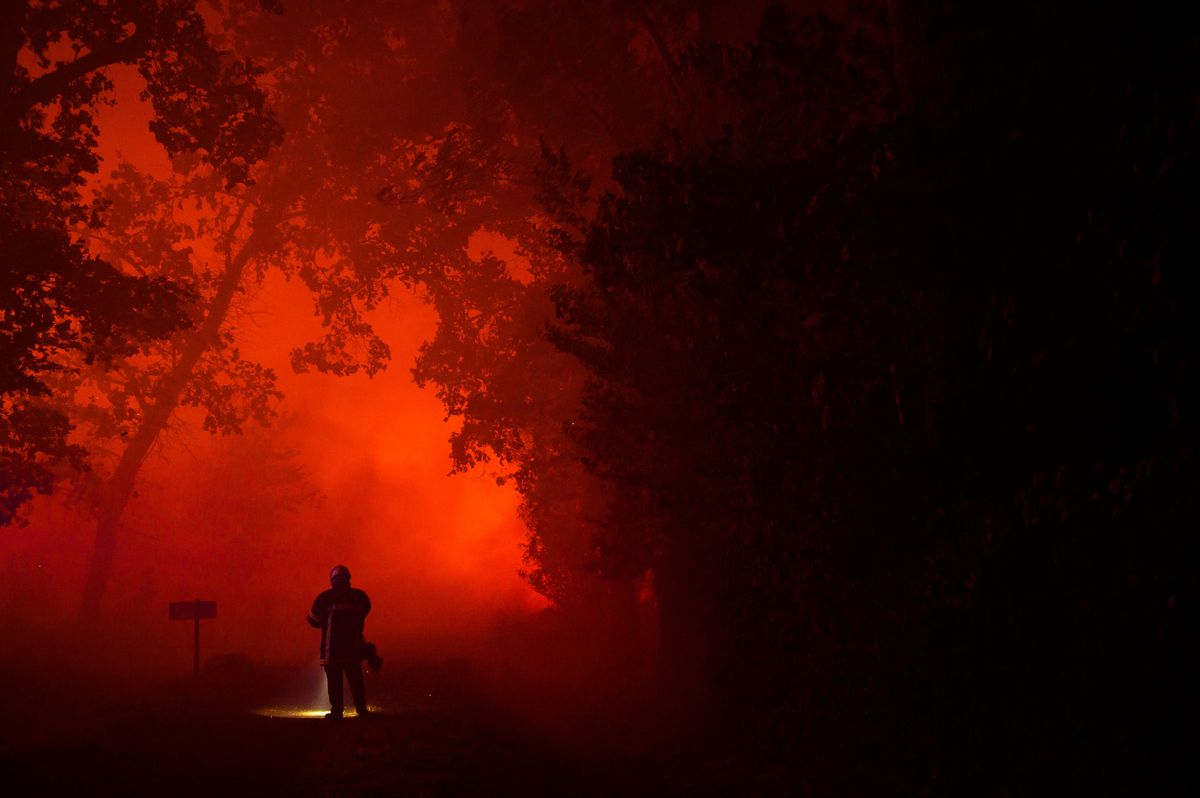 Un bombero se encuentra en una carretera que conduce a casas amenazadas por un incendio forestal en Saumos, cerca de Burdeos, suroeste de Francia, el 12 de septiembre de 2022.&nbsp; Foto: AFP
