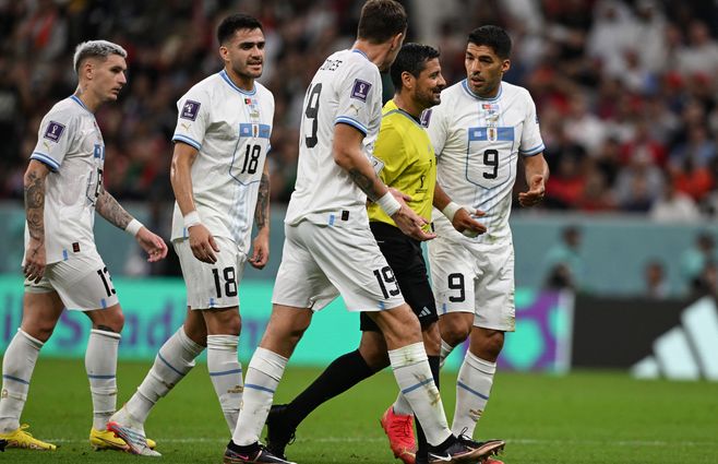 El árbitro Faghani junto a futbolistas uruguayos en el partido frente a Portugal. Foto: AFP