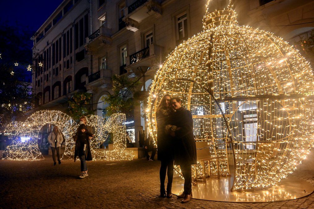 Personas posando frente a un letrero iluminado de 2021 en el centro de Atenas, Grecia.&nbsp;&nbsp;