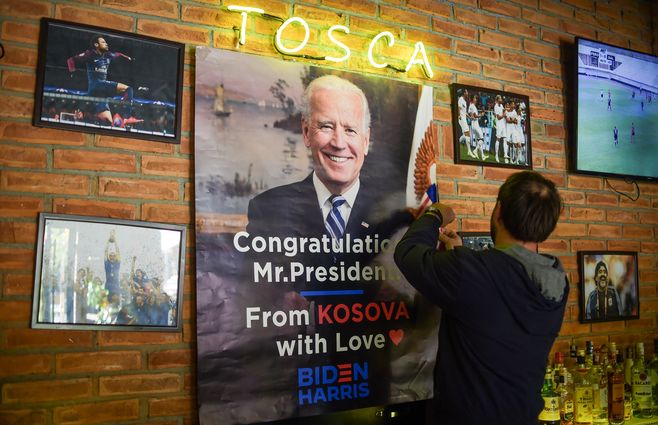 El dueño de un pub de Rahovec, Kosovo, coloca un cartel que felicita por anticipado a Joe Biden como nuevo presidente&nbsp;