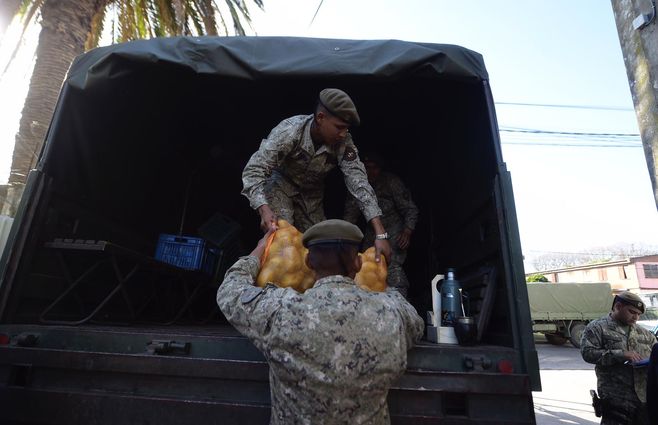 Personal de las Fuerzas Armadas carga alimentos en los camiones. Foto: FocoUy.