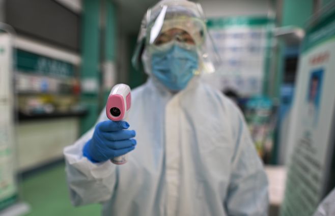 Un m&eacute;dico en China se prepara para tomar la temperatura