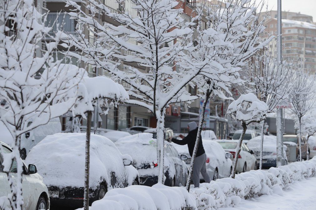 Un hombre remueve nieve de su auto en Ankara, Turquía