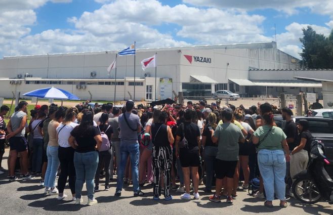 Empleados de Yazaki se reunieron en la puerta de la planta en Las Piedras, este jueves al mediodía, tras conocer la decisión de la empresa de cerrar e irse de Uruguay. Foto: Eduardo Castro, Subrayado.