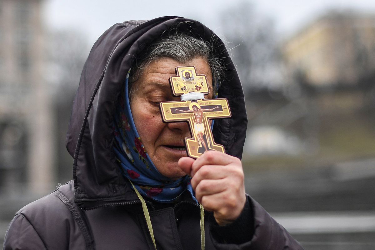 Una mujer religiosasostiene una cruz mientras reza en la plaza de la Independencia enKiev en la mañana del 24 de febrero de 2022.