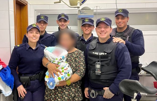 Los agentes de la Policía que asistieron el parto, con la madre y su bebé.&nbsp;