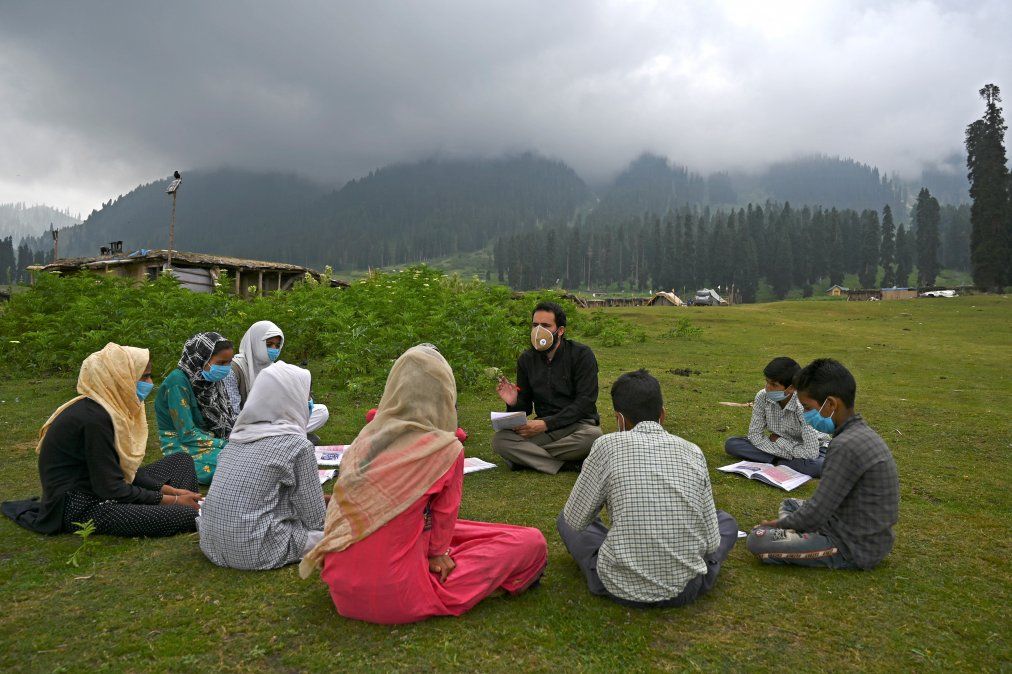 Los estudiantes asisten a una clase en su escuela al aire libre situada en la cima de una monta&ntilde;a en Doodhpathri.